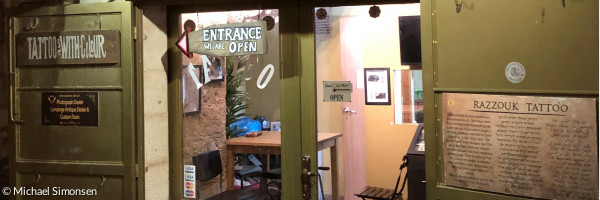 Eingangsbereich Tattoostudio Razzouk in Jerusalem bei Nacht. Innen hell